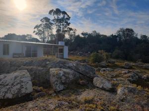 una casa en la cima de una colina con rocas en Las Carobas en Minas