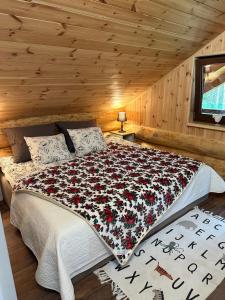 Un dormitorio con una cama grande en una cabaña. en Wikno Villa, en Nidzica