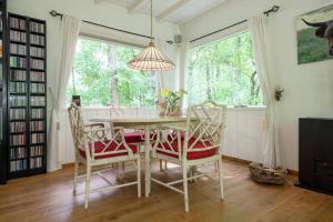 een eetkamer met een tafel en stoelen en een raam bij Het Boshuis in Dalfsen