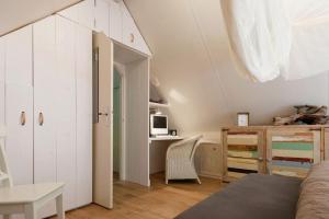 a bedroom with a bed and a desk in a room at Het Boshuis in Dalfsen