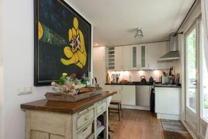 a kitchen with a large painting on the wall at Het Boshuis in Dalfsen