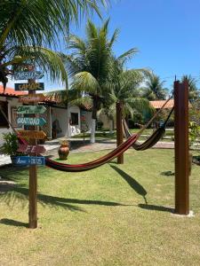 a playground with a hammock and street signs at Pousada Kaluanã in Japaratinga