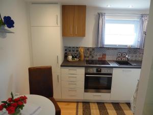 a kitchen with white cabinets and a sink and a table at erholungsraum Karsee - Ferienwohnung in Wangen im Allgäu