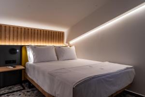 a bedroom with a large bed with white sheets at NERO SEASCAPE SUITES in Fanárion