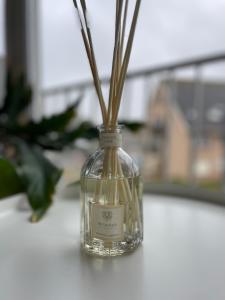 a glass bottle with sticks in it on a table at Studio Suite Lido in Koksijde