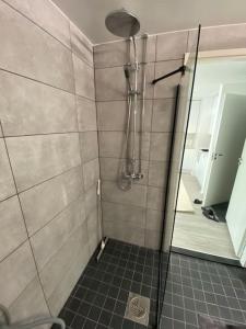 een douche met een glazen deur in de badkamer bij Meren läheisyydessä iso yksiö in Helsinki