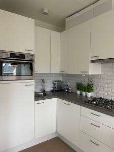 a white kitchen with white cabinets and appliances at Studio Suite Lido in Koksijde