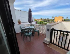 balcone con tavolo, sedie e ombrellone di Can Sastre a El Port