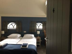 a bedroom with a large bed and two windows at Herberg d'n Driesprong in Zeeland