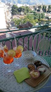 a table with drinks and food on a balcony at Casa Amari alla Zisa HOSTEL in Palermo