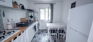 a white kitchen with a sink and a stove at la Sapinière in Saint-Vincent-de-Paul