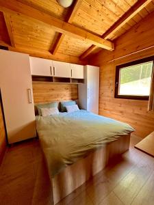 1 dormitorio con 1 cama en una cabaña de madera en Cabana Sia en Sibiu