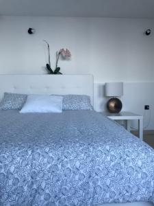 a bedroom with a bed with a blue comforter at Studio Apartman Lana 3 in Ičići