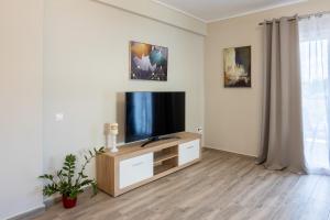 una sala de estar con TV de pantalla plana en un armario en Luxury & Cozy apartment en Messíni