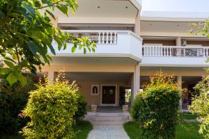 a large house with a balcony and bushes at Luxury & Cozy apartment in Messini