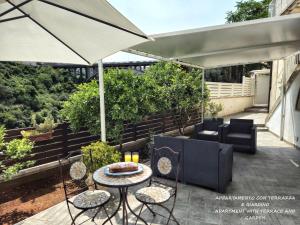 a patio with a table and chairs and an umbrella at Il Giardino Sulla Valle in Ragusa