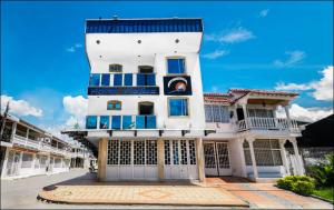 un grand bâtiment blanc avec un toit bleu dans l'établissement Hotel Najjez, à Villavicencio