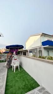 una donna in piedi su un balcone con tavolo e ombrellone di Appartamenti vacanze Marina di bibbona a Marina di Bibbona