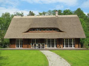 a house with a roof with chairs in front of it at Exklusives Holzhaus in Burg