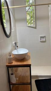 a bathroom with a white sink and a mirror at Casa con jardín, pileta, asador, y vistas al lago en Embalsina in Villa del Dique