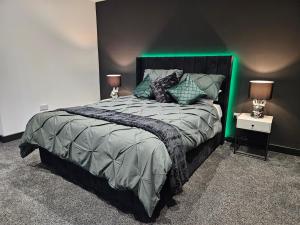a bedroom with a large bed with green lighting at Sun Inn - Boutique Apartments Bingley in Bradford