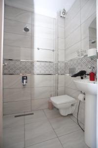 a bathroom with a shower and a toilet and a sink at RÜYA PANSİYON APART OTEL in Yukarı Kocaali +119 photos