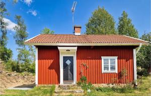 una pequeña casa roja con una puerta blanca en 3 Bedroom Amazing Home In Vrigstad en Vrigstad