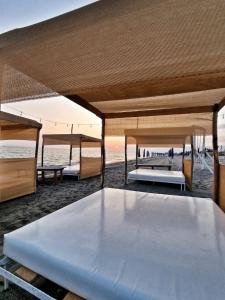 カステル・ヴォルトゥルノにあるBeach Suites - by Lido Scalzoneの白い大型ベッド(ビーチの上に座る)
