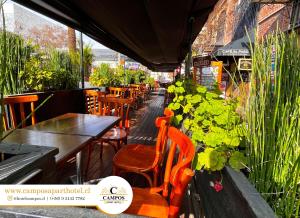 restauracja ze stołami, krzesłami i roślinami w obiekcie Apart Hotel Campos Rancagua w mieście Rancagua