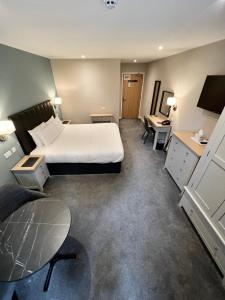 a hotel room with a bed and a desk at South Lawn Hotel in Lymington
