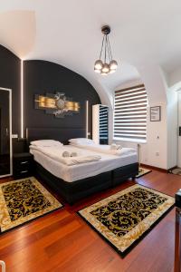 a bedroom with a large bed with a black wall at Central Studios Hermannstadt in Sibiu