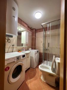 uma casa de banho com uma máquina de lavar roupa e um WC em Aleksandra 2 em Skopje