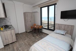 a bedroom with a bed and a desk and a television at RÜYA PANSİYON APART OTEL in Yukarı Kocaali