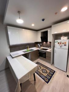 una pequeña cocina con nevera blanca y mesa en Modern Apartment PLEASE Inform me before check in, en Estambul