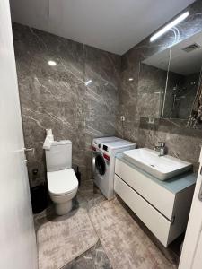 La salle de bains est pourvue de toilettes, d'un lavabo et d'un lave-linge. dans l'établissement Modern Apartment PLEASE Inform me before check in, à Istanbul
