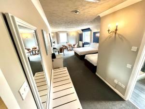 a hotel room with a bedroom and a bed and a mirror at South Lawn Hotel in Lymington