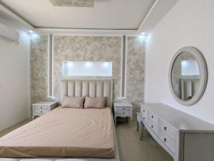 a bedroom with a bed and a desk and a mirror at Villa NIÇOISE DJERBA in Awlād ‘Umar