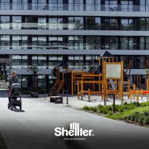 Um homem a andar de carrinho de bebé em frente a um edifício. em Seaside Shellter Rogowo em Rogowo