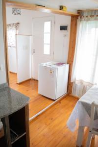 a kitchen with a white refrigerator and a wooden floor at La serena in San Carlos de Bariloche