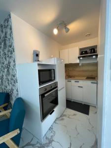 a kitchen with a stove and a white refrigerator at Appartement vue sur la Charente in Soubise +8 photos