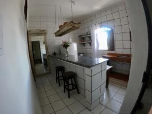 una cocina con encimera y algunos taburetes en ella en Apartamento Center Braga, en Trancoso