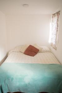 a bed in a white room with avertisementatronatronstrationstrationstrationstrationstration at La serena in San Carlos de Bariloche