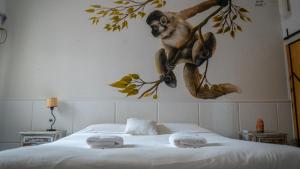 a monkey hanging on a wall above a bed at Yunga in Salta