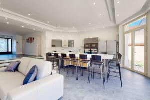 a living room with a white couch and a kitchen at 07.Studio#Creteil#Loft#Cinéma in Créteil
