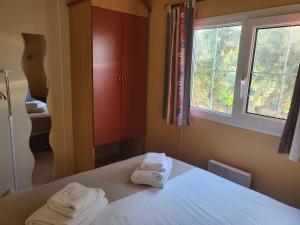 a bedroom with two towels on a bed with a window at Monte da Caldeirinha in Luz de Tavira