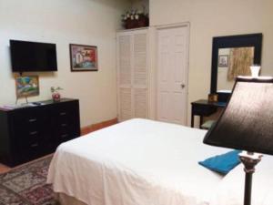 1 dormitorio con 1 cama, vestidor y TV en Casita Montana Hotel en Ajijic