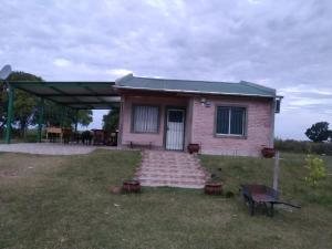 a small pink house with a porch and a table at La Solita in Mercedes