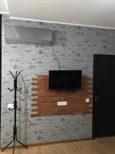 提比里斯的住宿－Sioni Apartment，砖墙上配有电视的房间