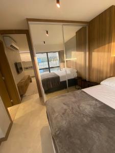 a bedroom with two beds and a large mirror at Apartamento novo de alto padrão e aconchegante#224 in Brasilia