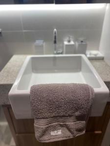 a sink in a bathroom with a towel on it at Apartamento novo de alto padrão e aconchegante#224 in Brasilia